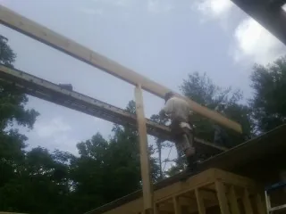 Carpenter setting a ridge beam over a new addition frame — Ice Dam Removal by Roofing Brothers in Long Branch