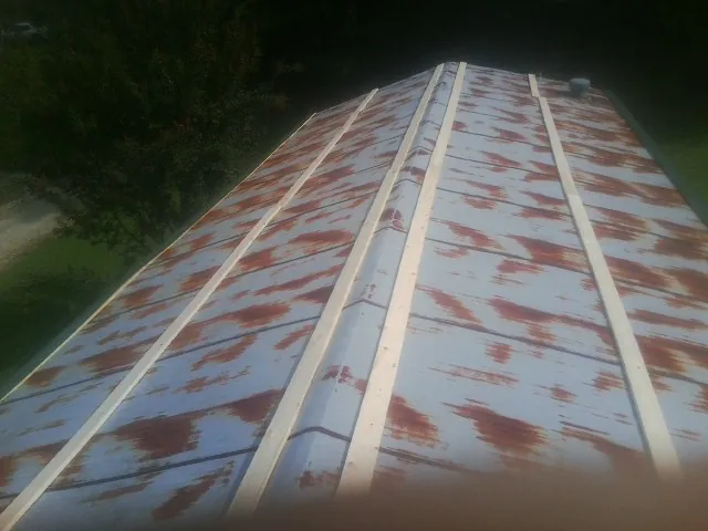 Rusted metal roof panels with new wood purlins before replacement — Storm Damage Roof Repair in Long Branch by Roofing Brothers