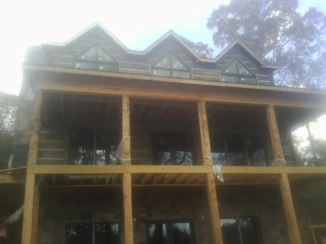 Dormers and porch framing on a large log home under construction — Roof Coating work by our crew in Long Branch