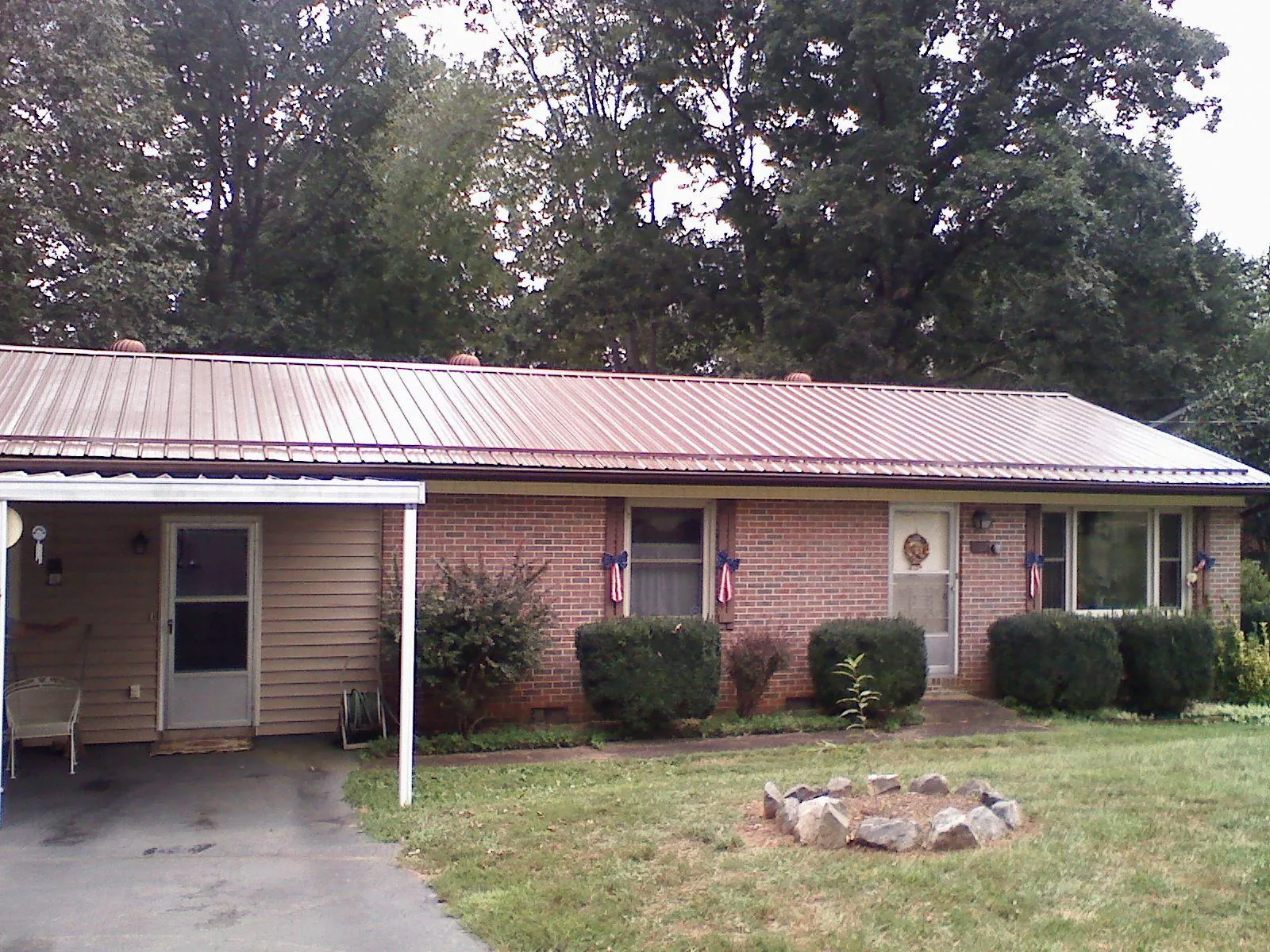 Bronze metal roof and carport on a brick ranch home — Roof Repair work by our crew in Long Branch