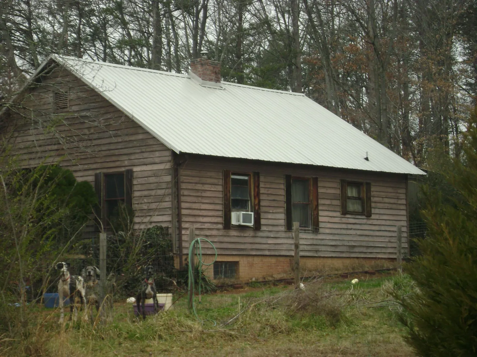 White metal roof on an old wood sided farmhouse, from a Metal Roof Installation job in Long Branch